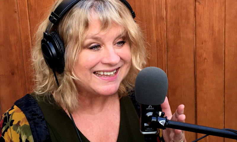 Smiling woman recording podcast with microphone